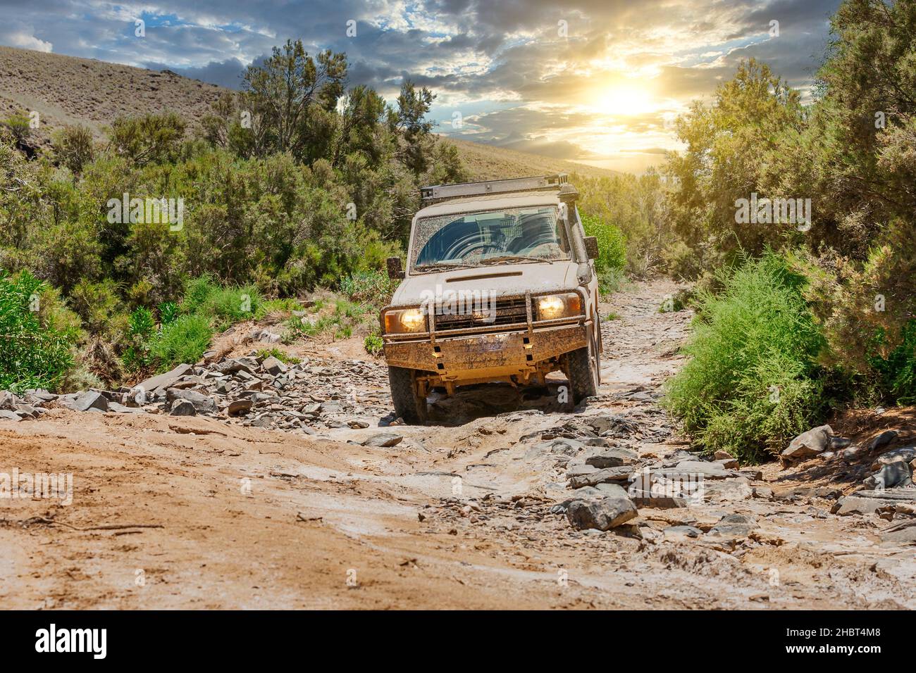 Off roading with an all terrain vehicle through a dry riverbed in The Arkaroola Wilderness Sanctuary located in the the Northern Flinders Ranges Stock Photo