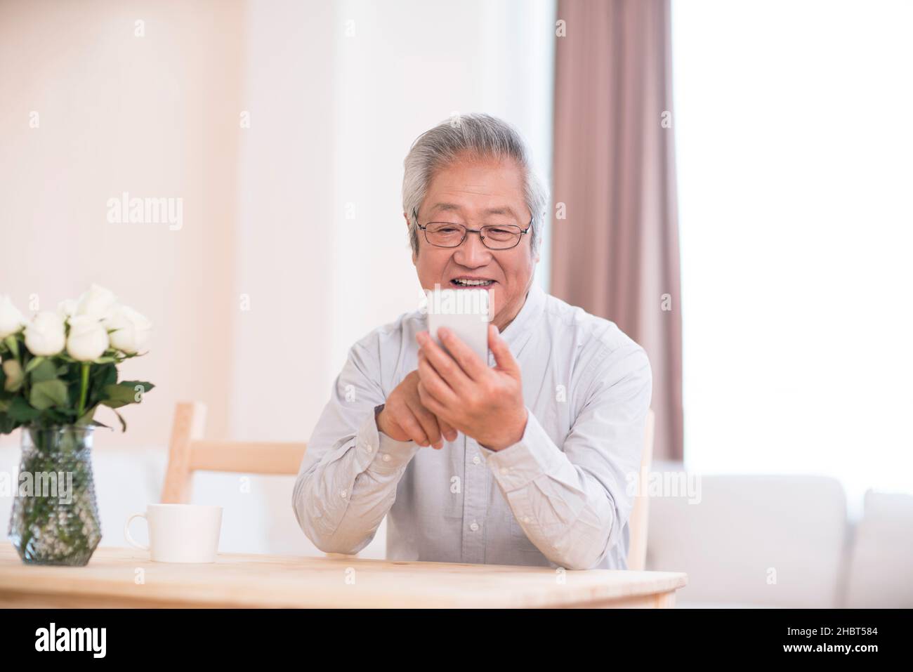 Older man using a smartphone at home Stock Photo