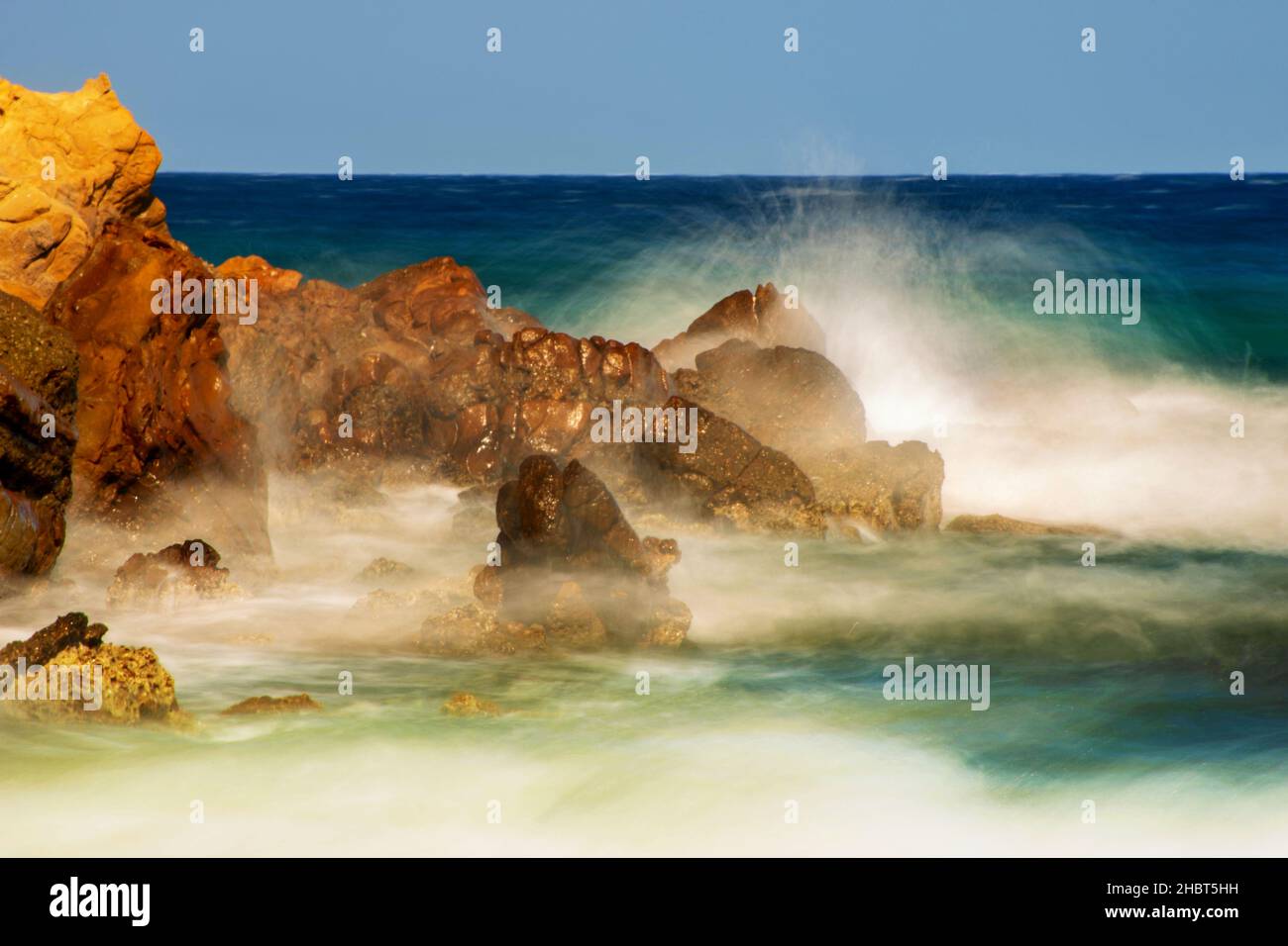 Power of sea surf, stormy water sprays high on rock cliff in windy sunny summer day. Limnos, Greece. Stock Photo