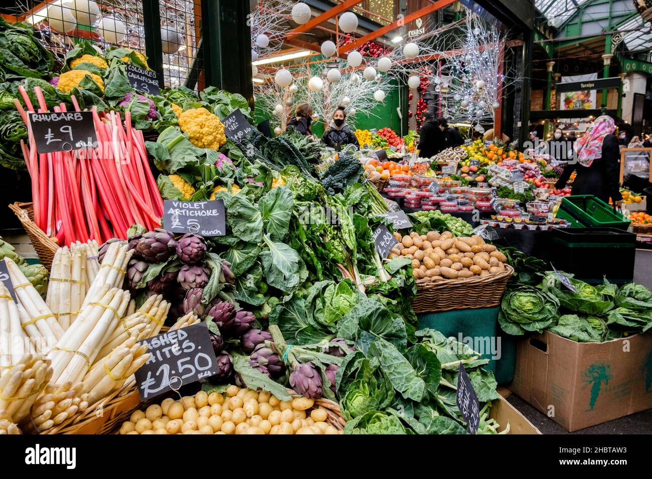 Large display of fresh vegetable produce on stall at Borough Market during leadup to Christmas