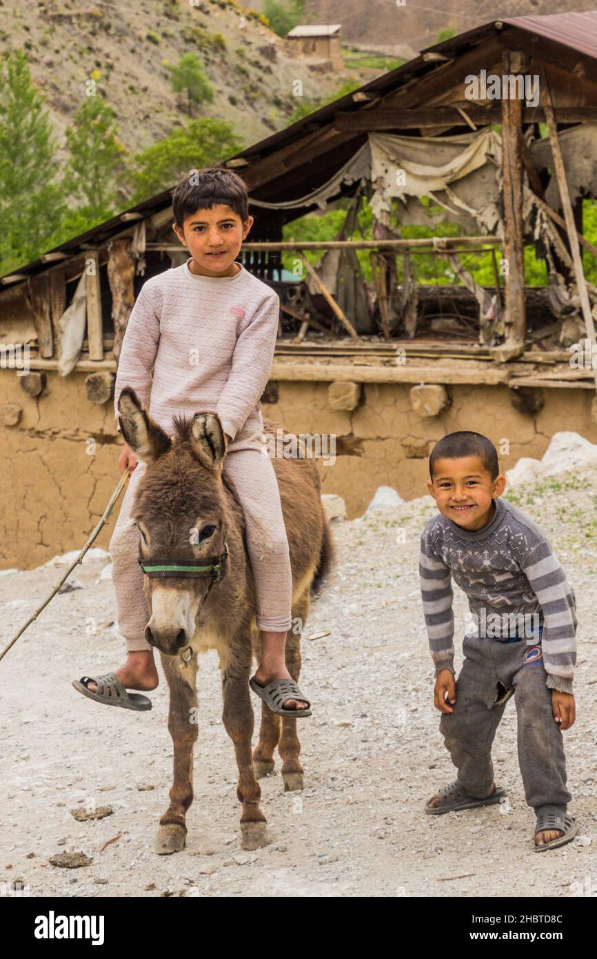 HAFT KUL, TAJIKISTAN - MAY 11, 2018: Donkey riding boy in Marguzor Haft Kul in Fann mountains, Tajikistan Stock Photo