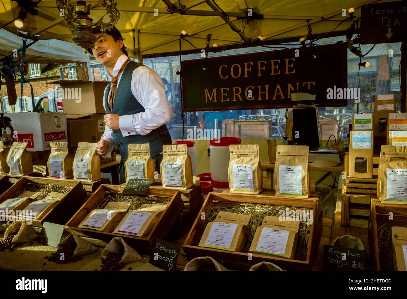 Stratford upon Avon, UK - A Coffee Merchant at the Victorian Christmas Market wearing period clothing. A variety of coffee beans are on offer. Stock Photo