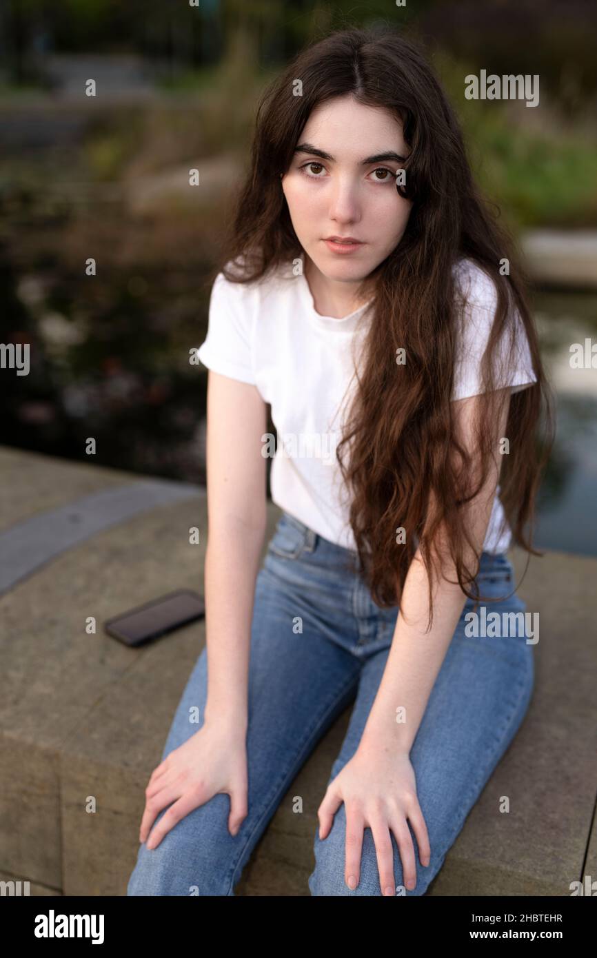 Closeup of Teenage Woman Seated by Fountain Stock Photo