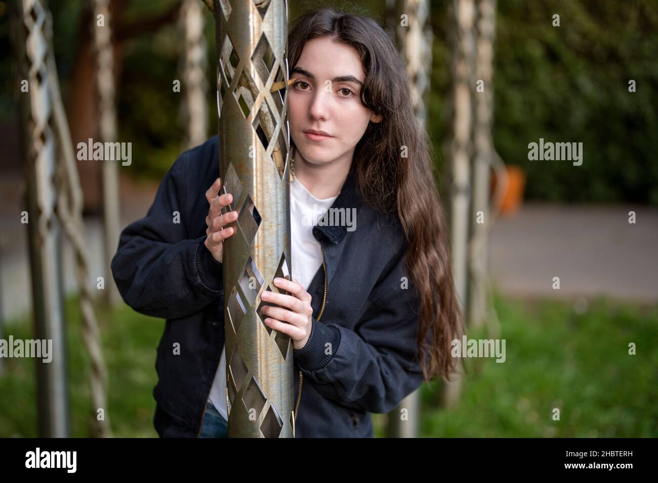 Teenage Woman Standing Holding Metal Poles Stock Photo