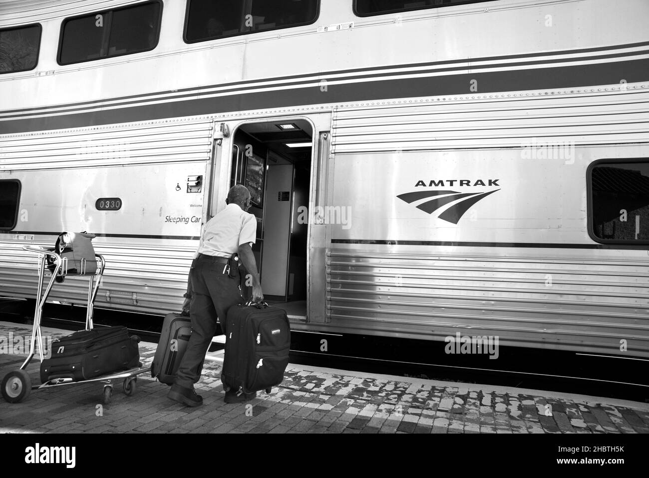 An Amtrak porter helps load passenger luggage at a scheduled stop for the Southwest Chief in Lamy, New Mexico. Stock Photo