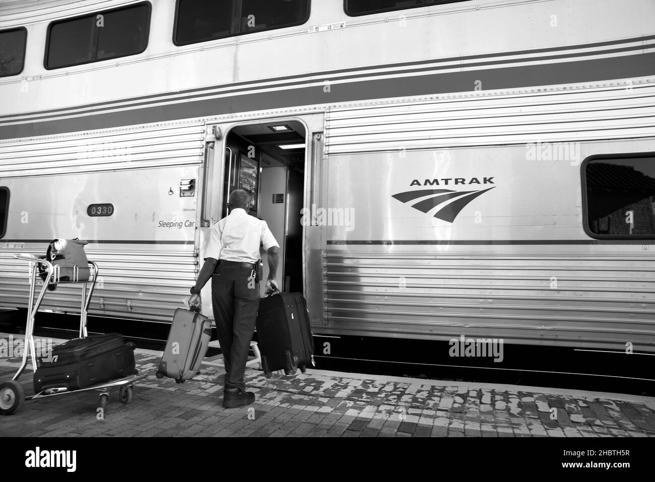 An Amtrak porter helps load passenger luggage at a scheduled stop for the Southwest Chief in Lamy, New Mexico. Stock Photo