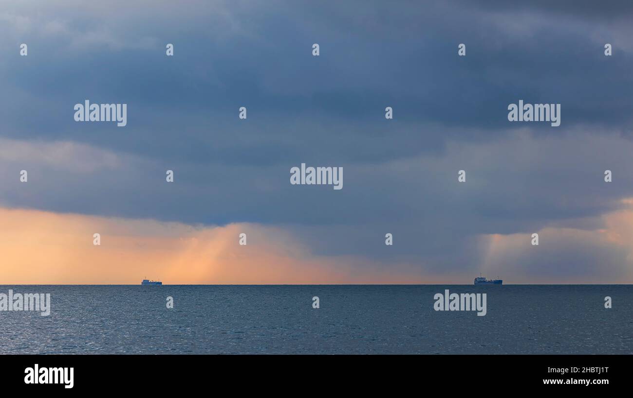 Two ships on the horizon in cloudy weather Stock Photo - Alamy