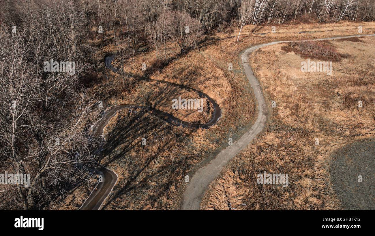 Hiking trail with stream alongside it in autumn woods Stock Photo