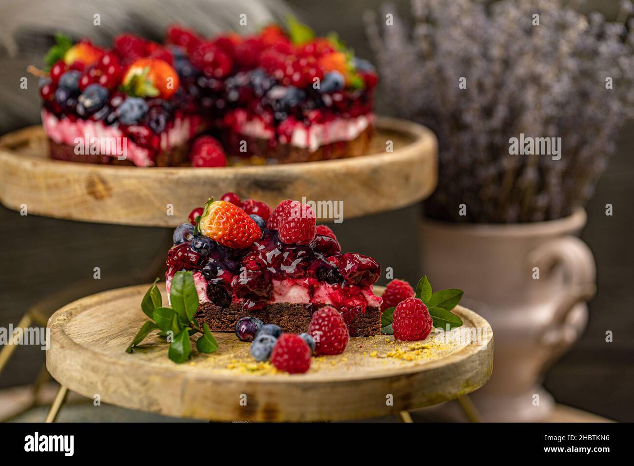 Chocolate cake with berries on top, triangle slice cake, close up Stock Photo