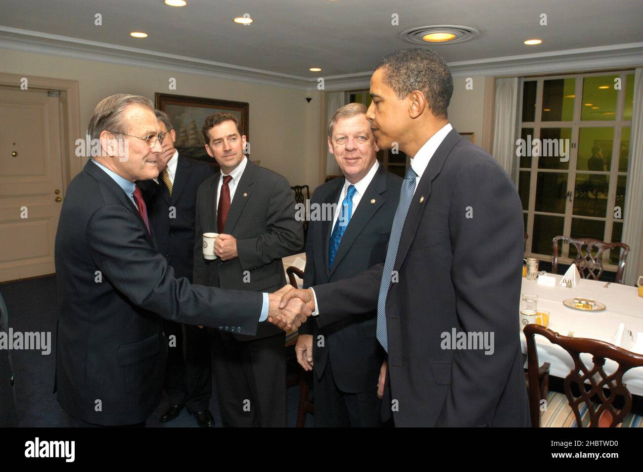 Secretary of Defense Donald Rumsfeld greets Senators Obama, Isakson, and DeMint at a breakfast for new members ca.  2005 Stock Photo