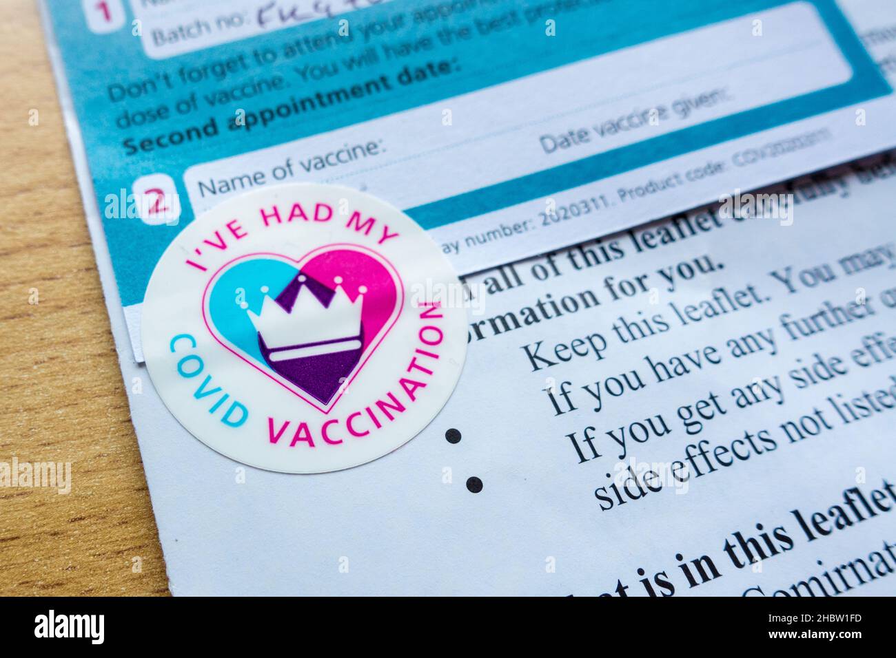 Covid Booster Jab vaccination card and leaflet with sticker Stock Photo