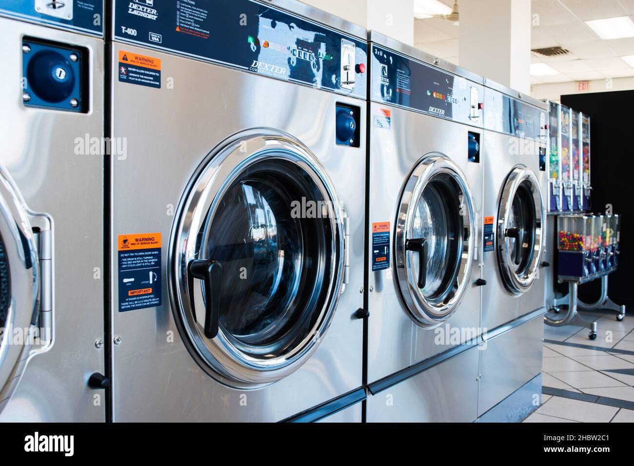 A row of heavyduty washing machines at the laundromat Stock Photo Alamy