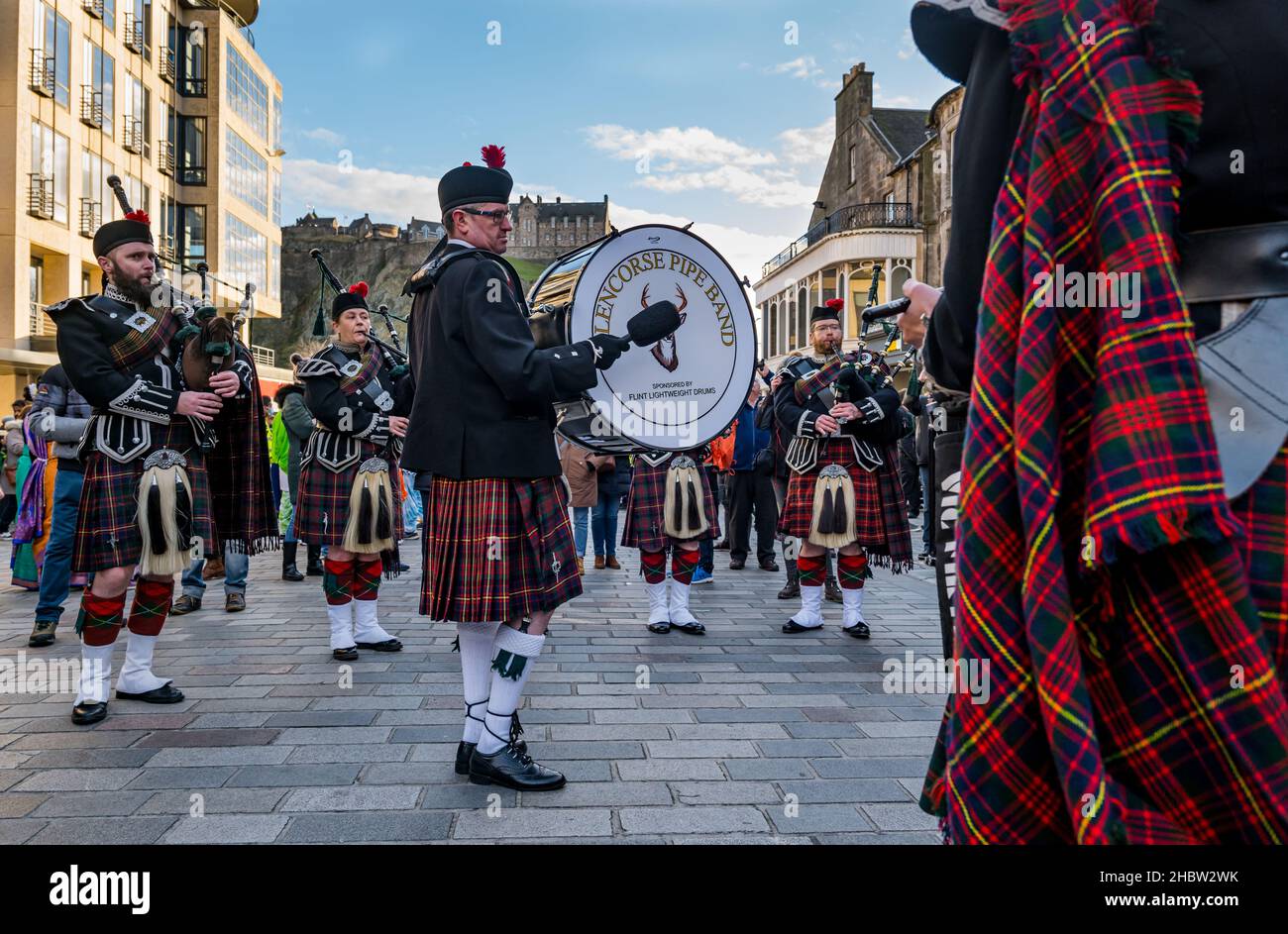 Scottish pipe band with man beating drum and bagpipe players at Diwali festival event with Edinburgh castle backdrop, Edinburgh, Scotland, UK Stock Photo