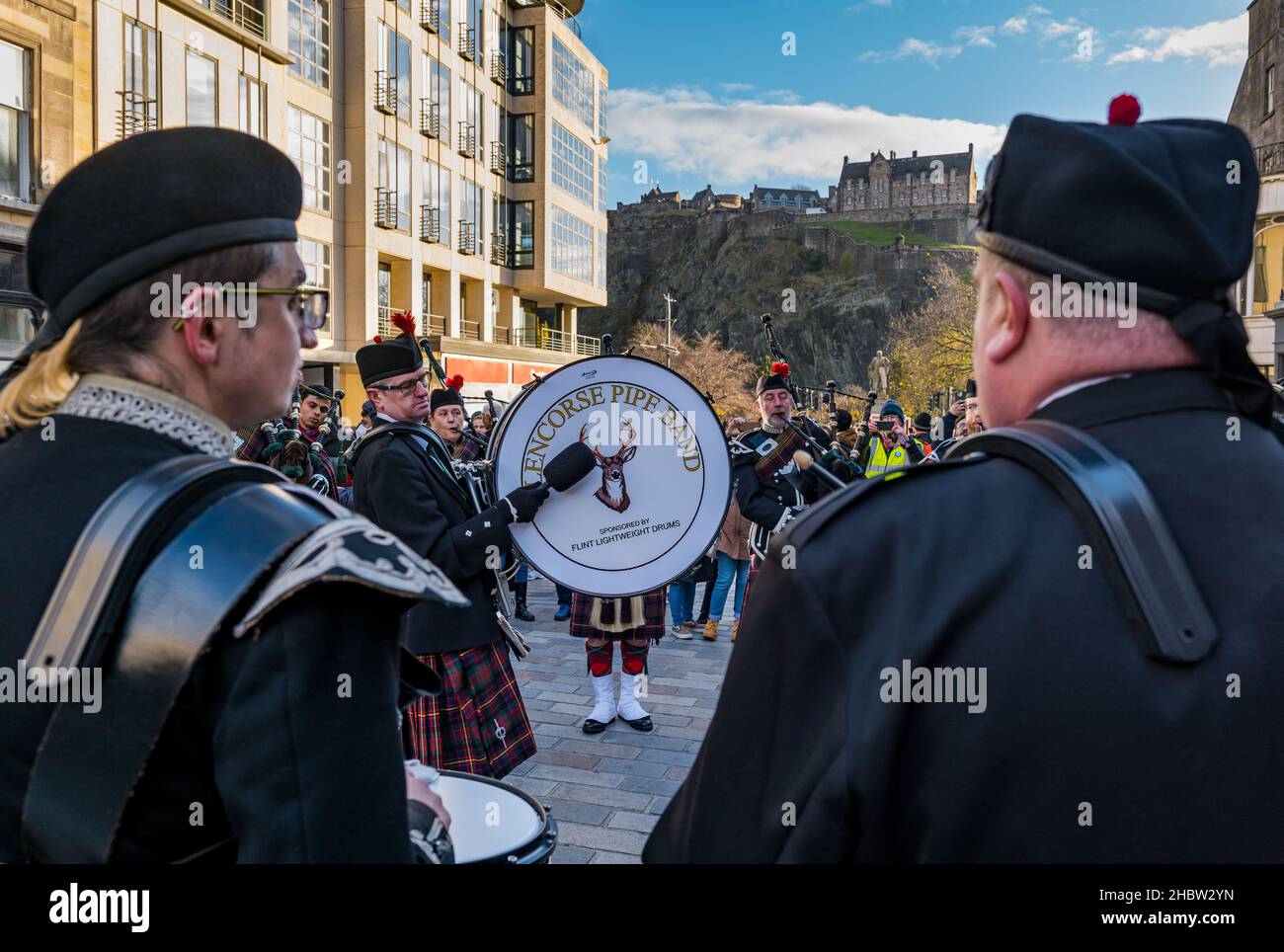 Scottish pipe band with man beating drum and bagpipe players at Diwali festival event with Edinburgh castle backdrop, Edinburgh, Scotland, UK Stock Photo