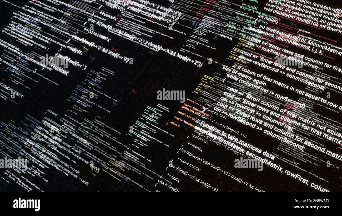 Abstract symbols flying diagonally on black screen background. Computer program codes running in a scrolling motion on a PC monitor display. Stock Photo