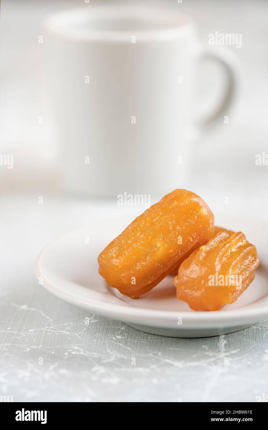 Traditional dessert with sherbet, one of the traditional sweet food known as 'tulumba' in Turkish, Turkey. Turkish food on table against coffee cup. s Stock Photo