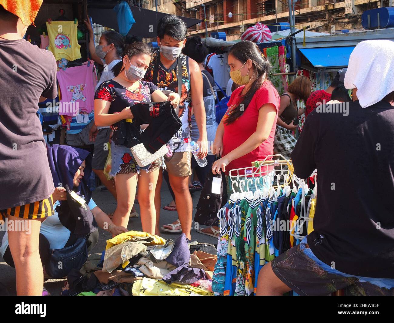 Manila, Philippines. 5th Jan, 2012. A couple seen carefully inspecting clothes at Divisoria, during the shopping session.As shoppers begin to flock at this popular shopping destination for the upcoming holiday season in search for best Christmas deals, the Department of Health (DOH) reminded holiday shoppers to take caution as the risk of getting corona virus (Covid-19) is high in crowded areas. (Credit Image: © Josefiel Rivera/SOPA Images via ZUMA Press Wire) Stock Photo