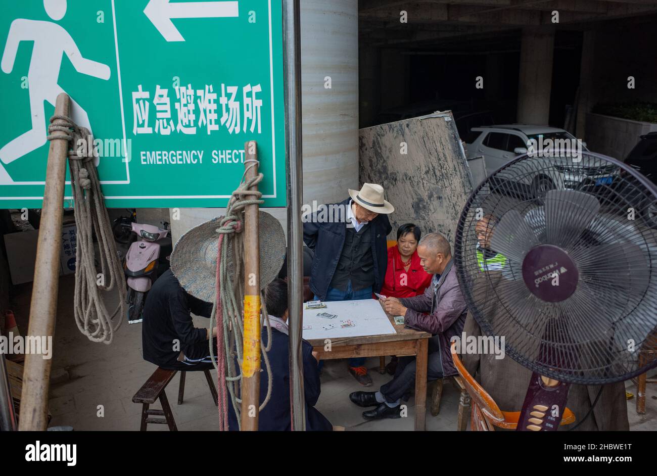Group of people playing cards.outside of a parking lot. Chongqing China Stock Photo