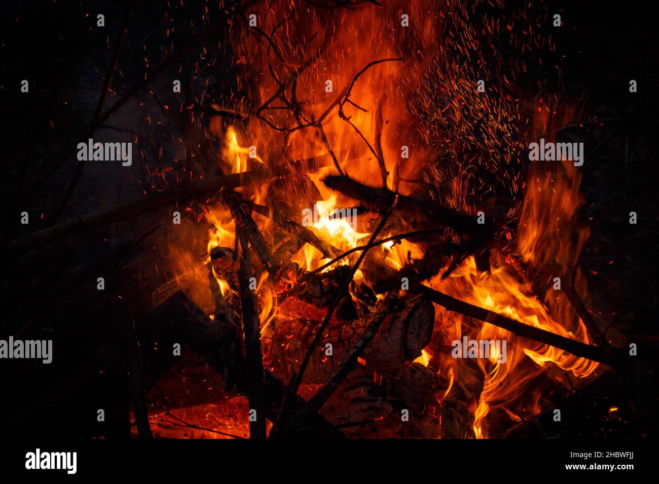 Campfire flame with sparks flying up at night Stock Photo - Alamy