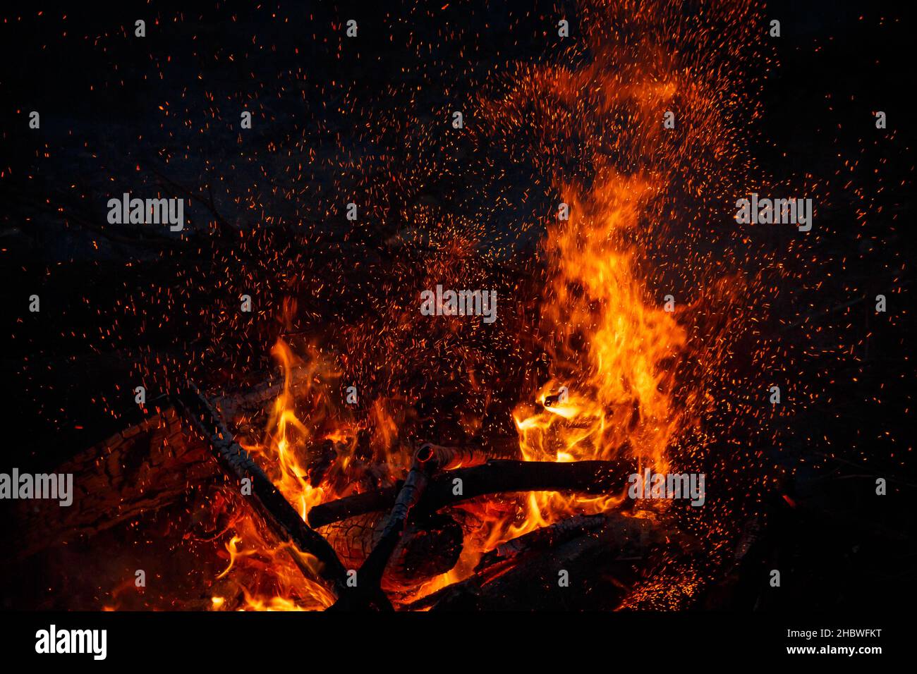 Campfire flame with sparks flying up at night Stock Photo - Alamy