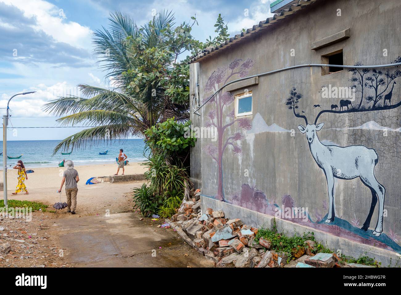 Small alley at Tam Ky that goes to the ocean with murals on painted walls. Stock Photo