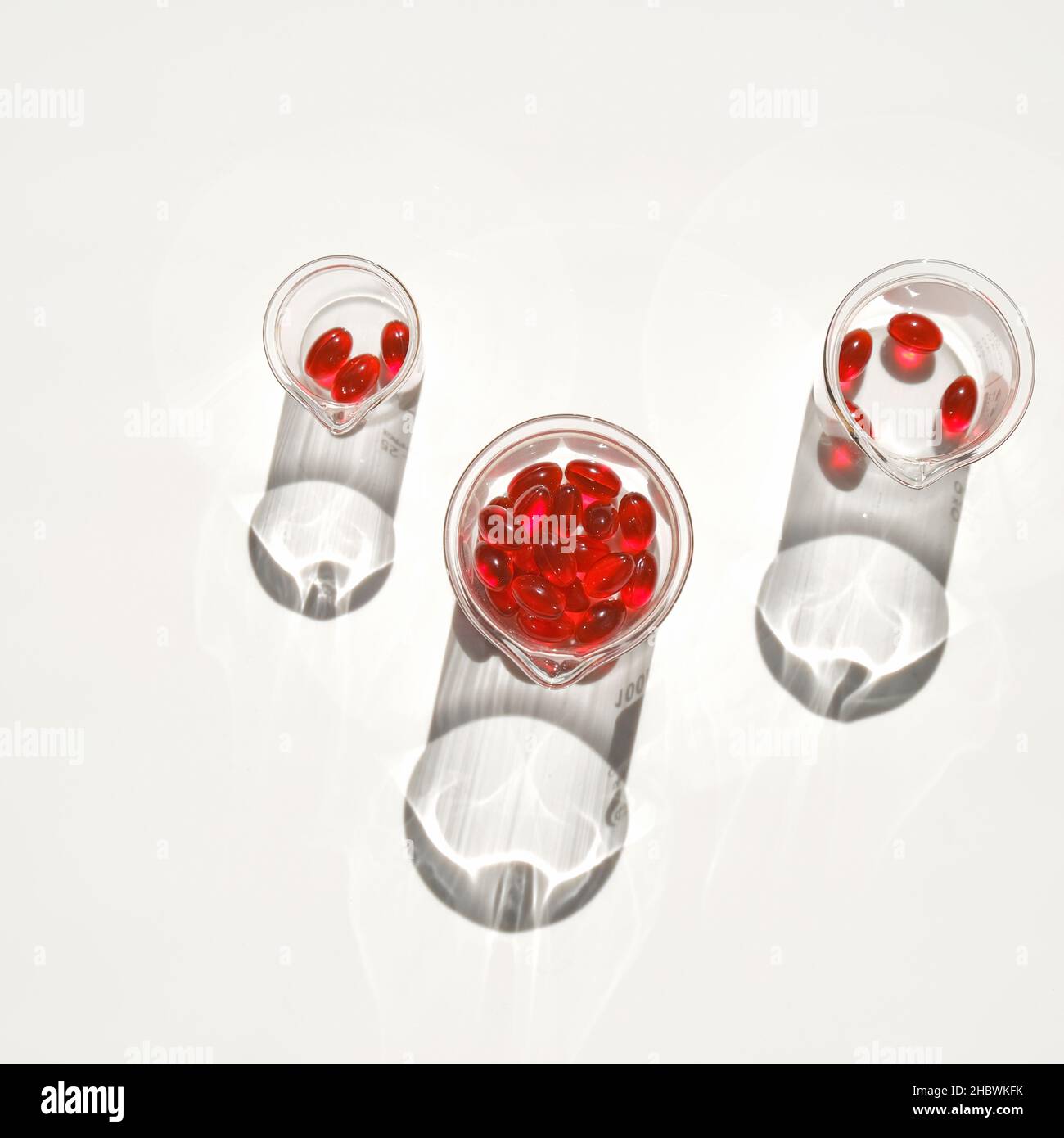 Krill oil capsules in laboratory transparent flasks on a white background.omega fatty acids.Natural supplements. red krill oil.Healthy eating and food Stock Photo