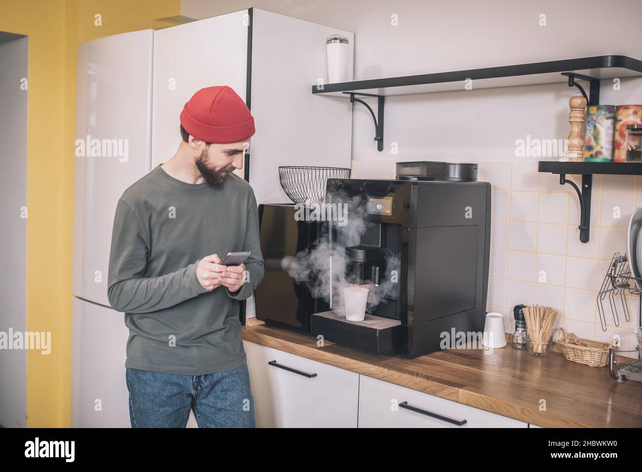 Guy looking at making coffee in coffee machine Stock Photo Alamy