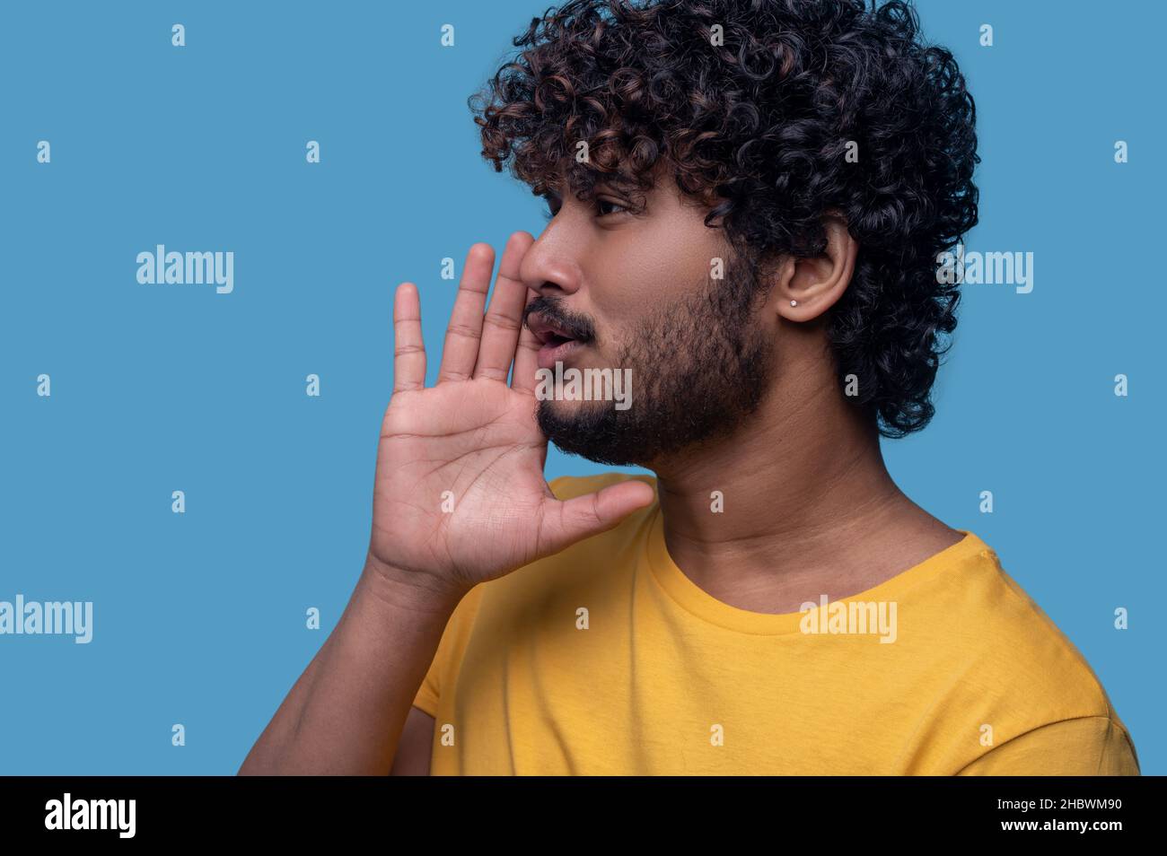 Focused good-looking young Indian man calling someone Stock Photo