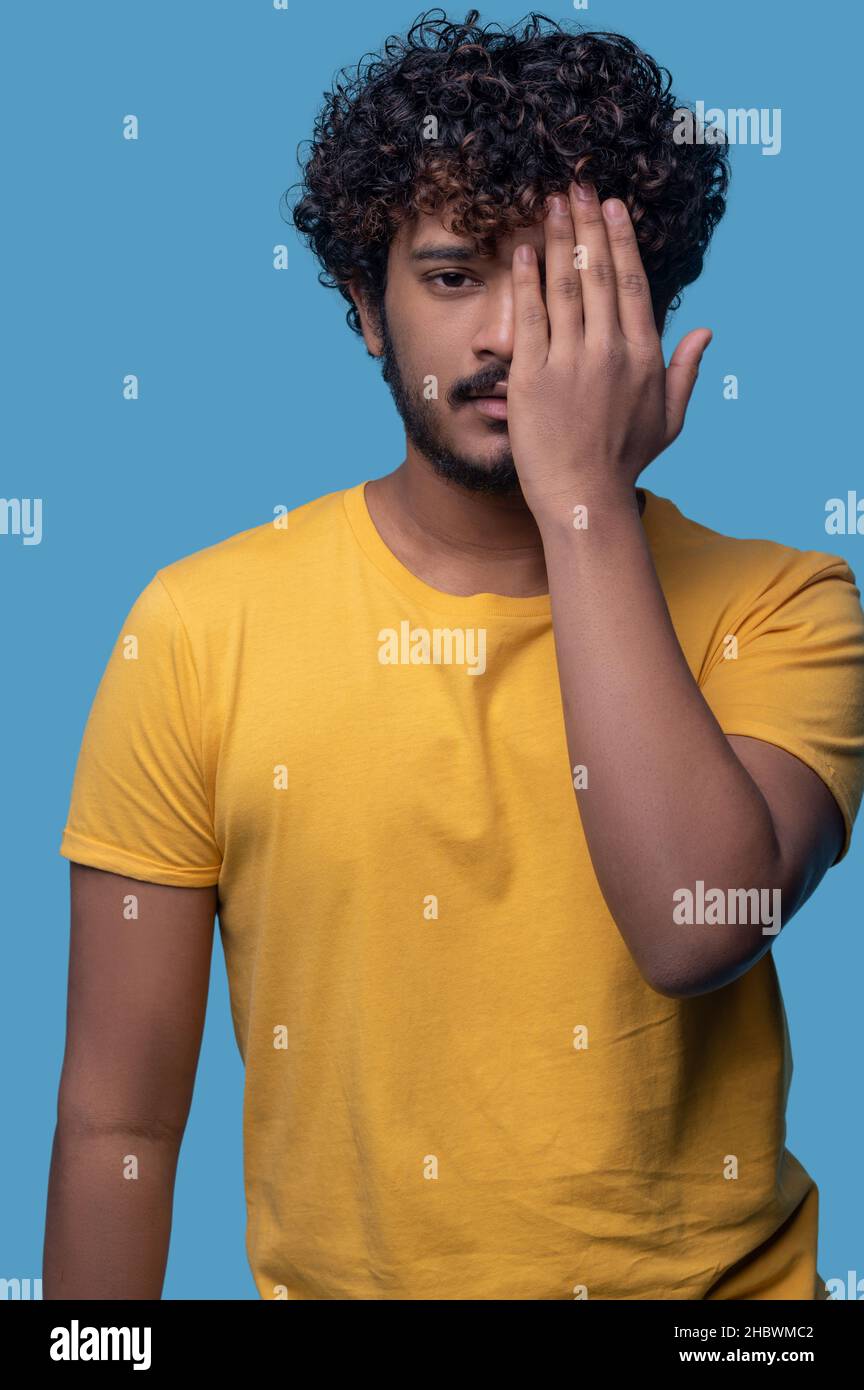 Serious cute Indian guy doing a facepalm Stock Photo