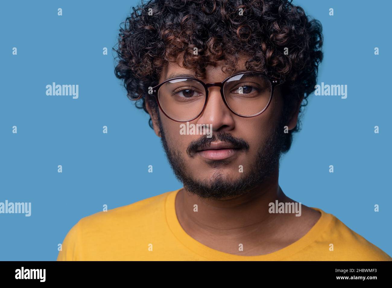 Serene man in trendy spectacles staring ahead Stock Photo