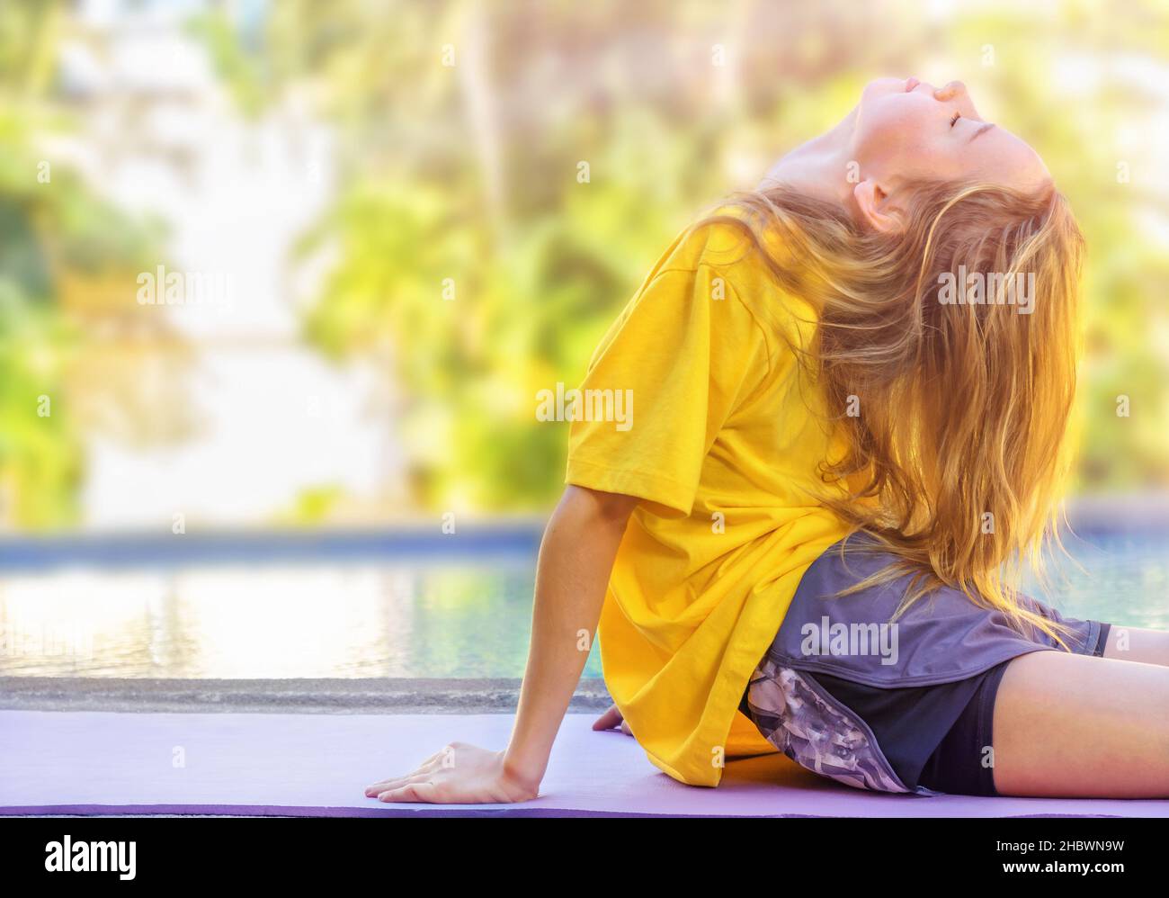 Teenage girl doing exercises during morning workout outdoors Stock Photo