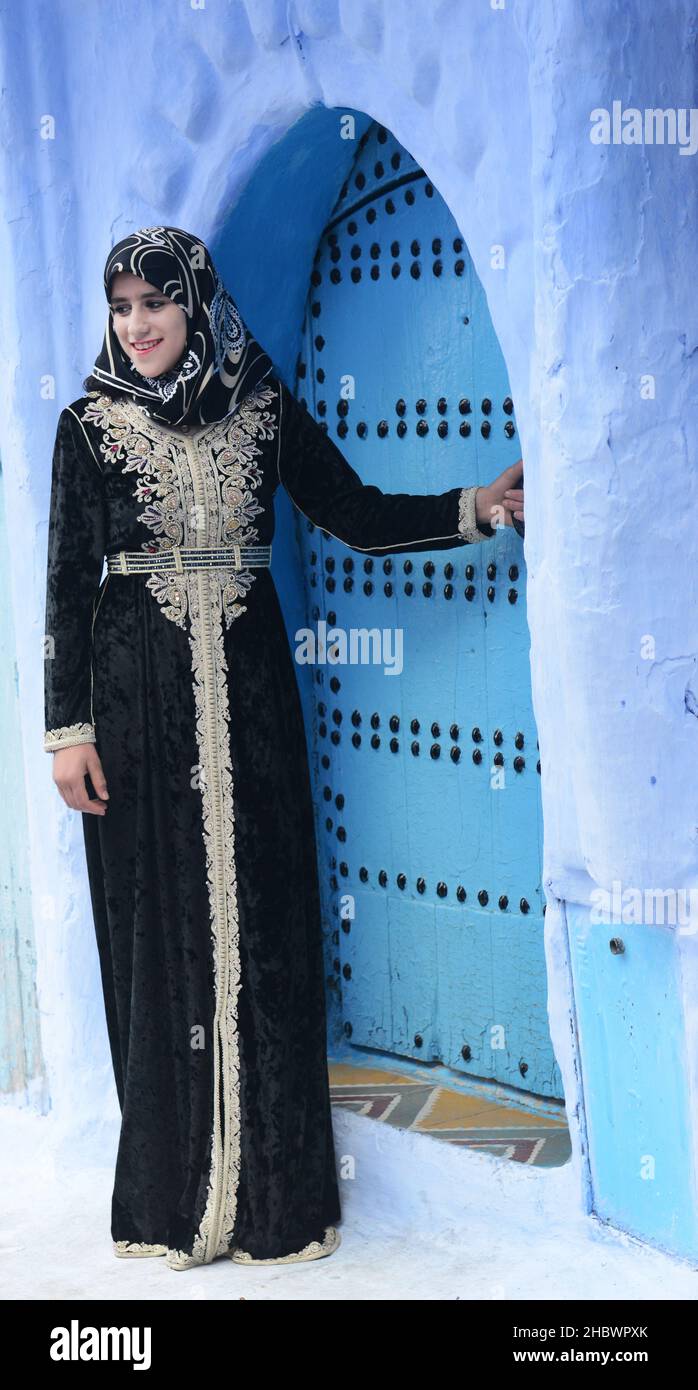 An Arab tourist posing by a traditional door in Chefchaouen, Morocco. Stock Photo