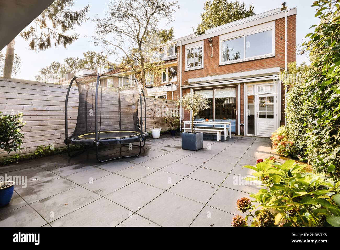 Lovely courtyard with wooden bench and trees Stock Photo - Alamy