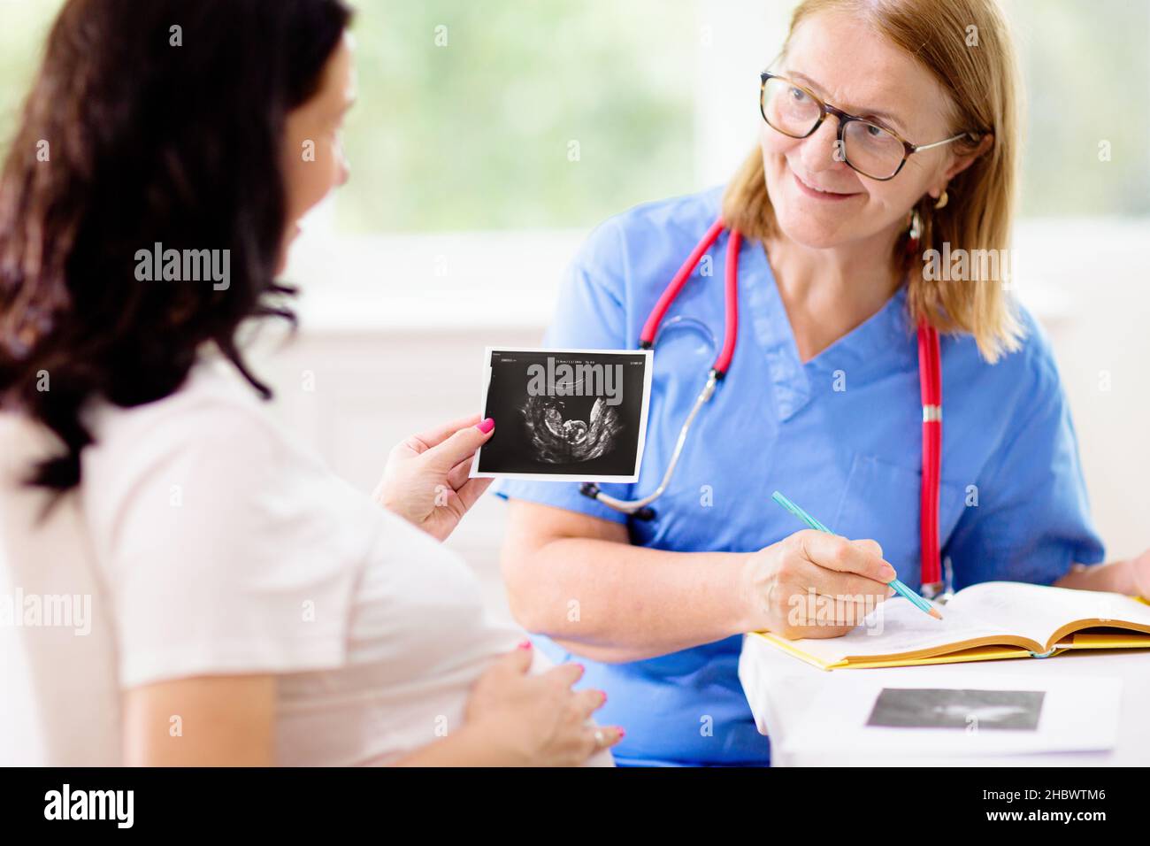 Doctor examining pregnant woman. Pregnancy check. Young Asian female at ...