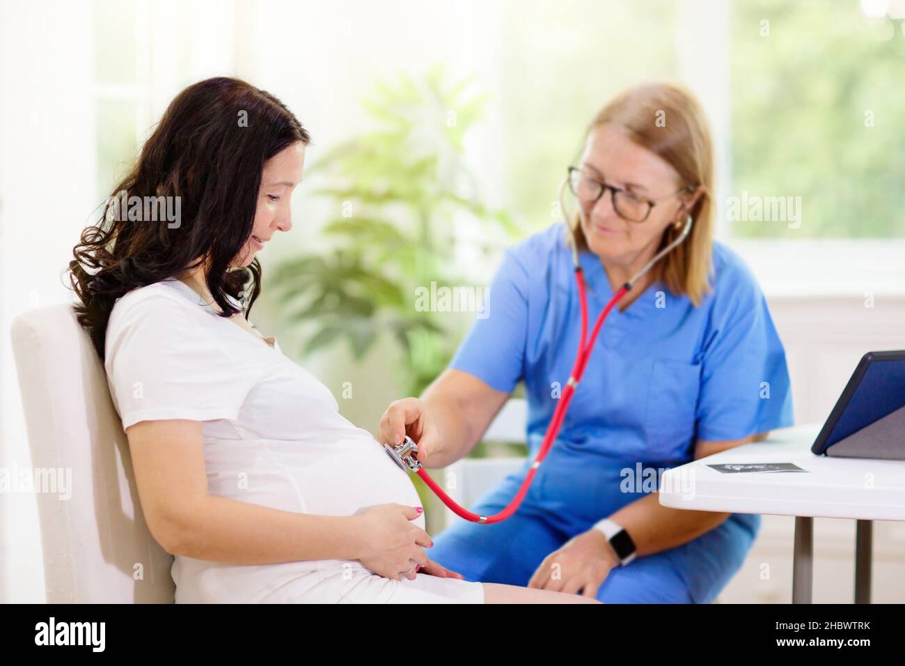 Doctor examining pregnant woman. Pregnancy check. Young Asian female at gynecologist  office for prenatal exam. Ob gyn showing patient baby sonogram Stock Photo  - Alamy