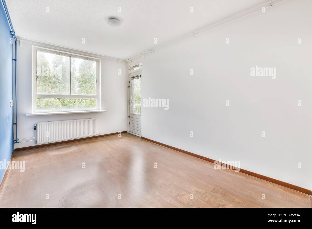 Lovely room with a window and one blue wall Stock Photo - Alamy