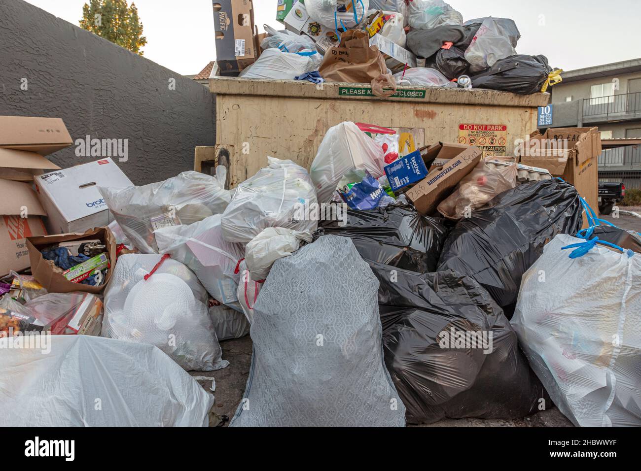 Trash overflowing from dumpster Stock Photo