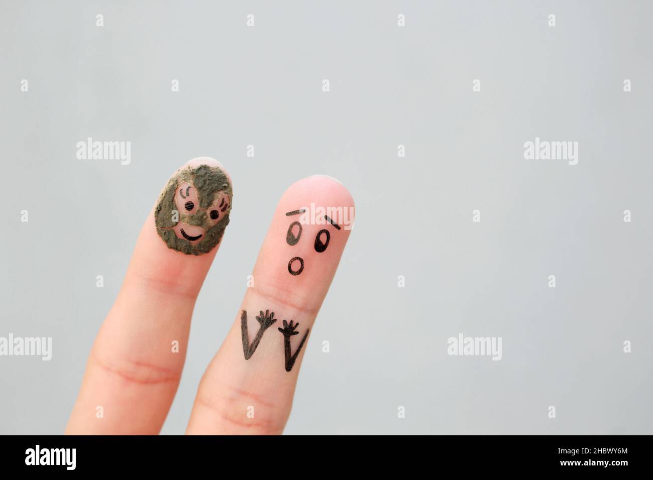 Fingers art of couple. Husband saw his wife with clay face mask and was afraid. Stock Photo