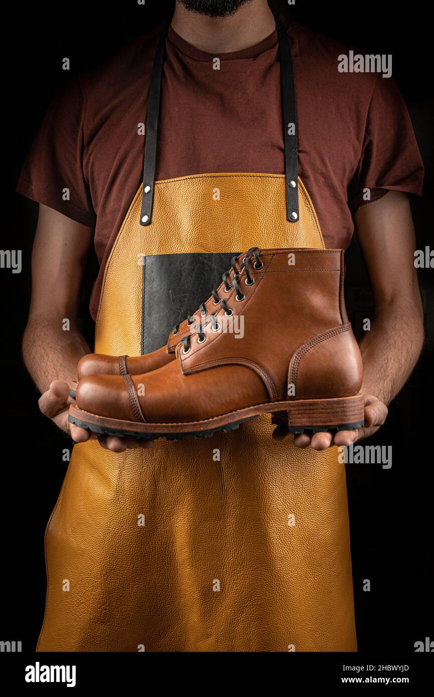 Cobbler holding pair of brown leather shoes Stock Photo Alamy