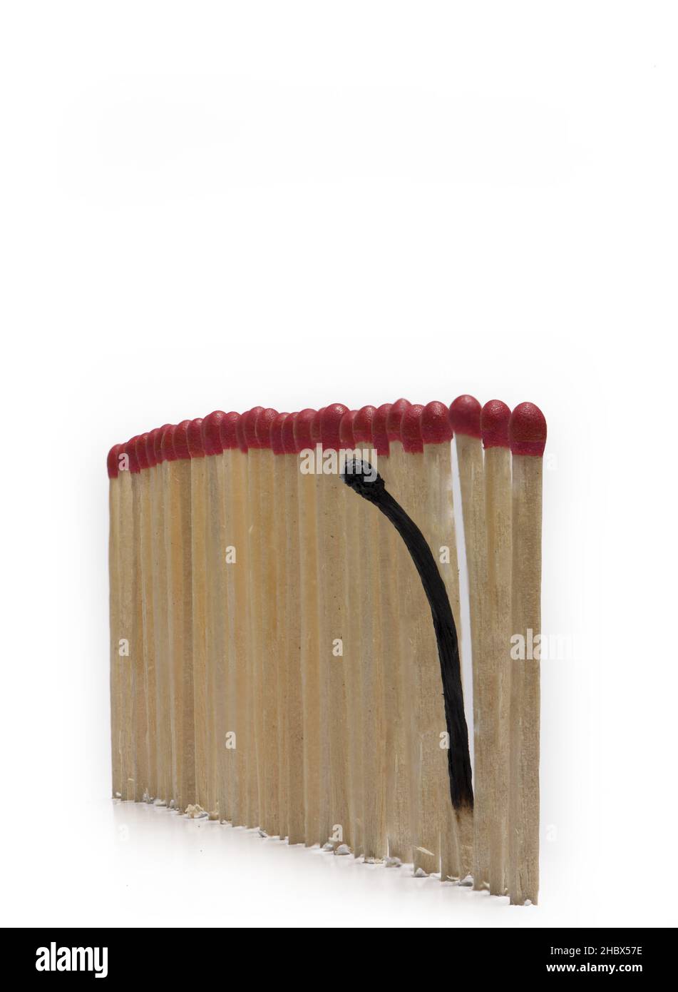 Close up of matches in an even row with a burned match behaving