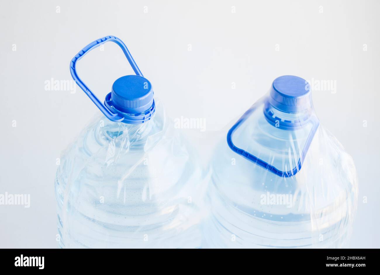 Natural Spring Water in five liter bottles on the white surface with own with nylon packing. Stock Photo