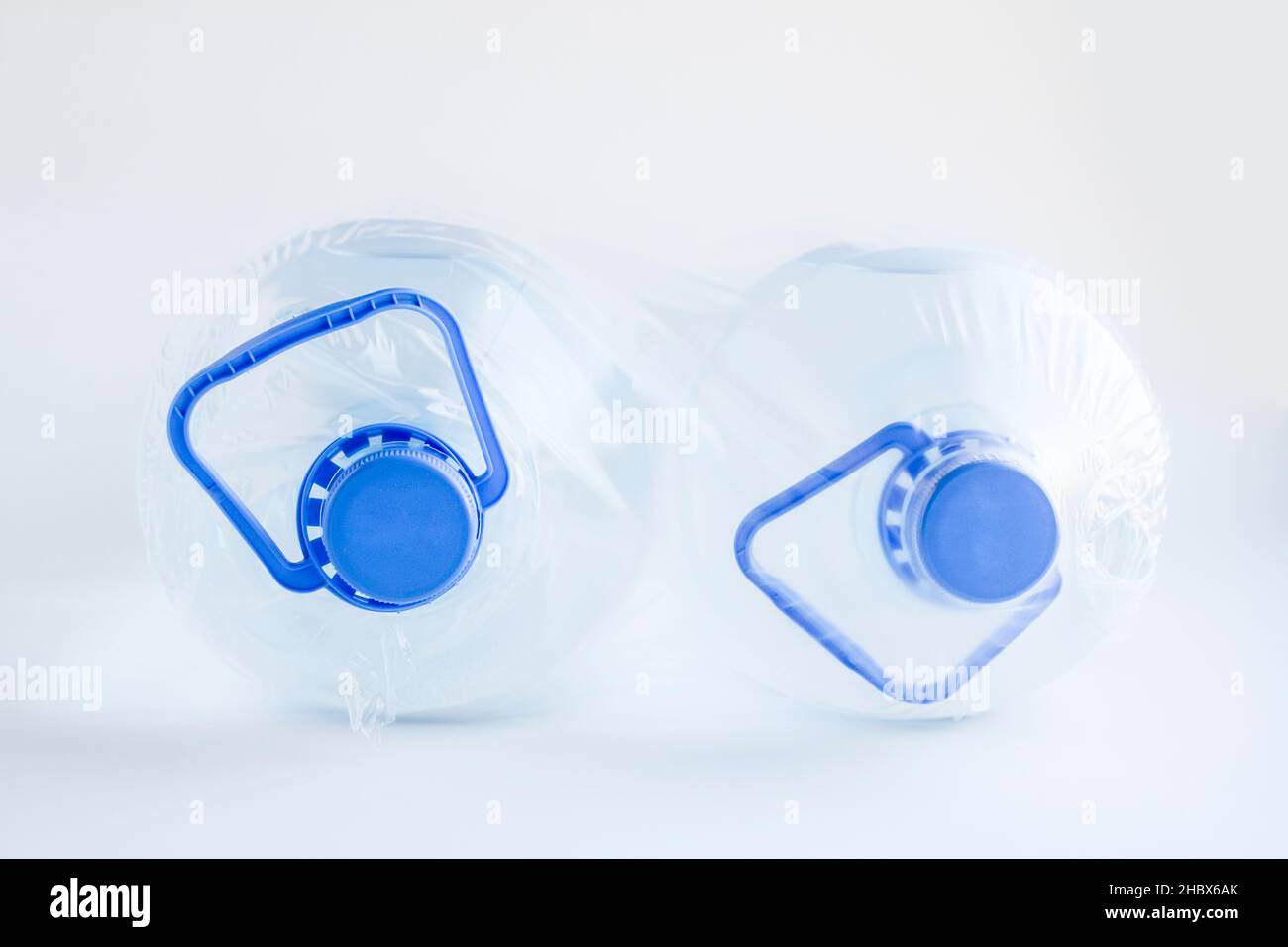 Natural Spring Water in five liter bottles on the white surface with own with nylon packing. Stock Photo