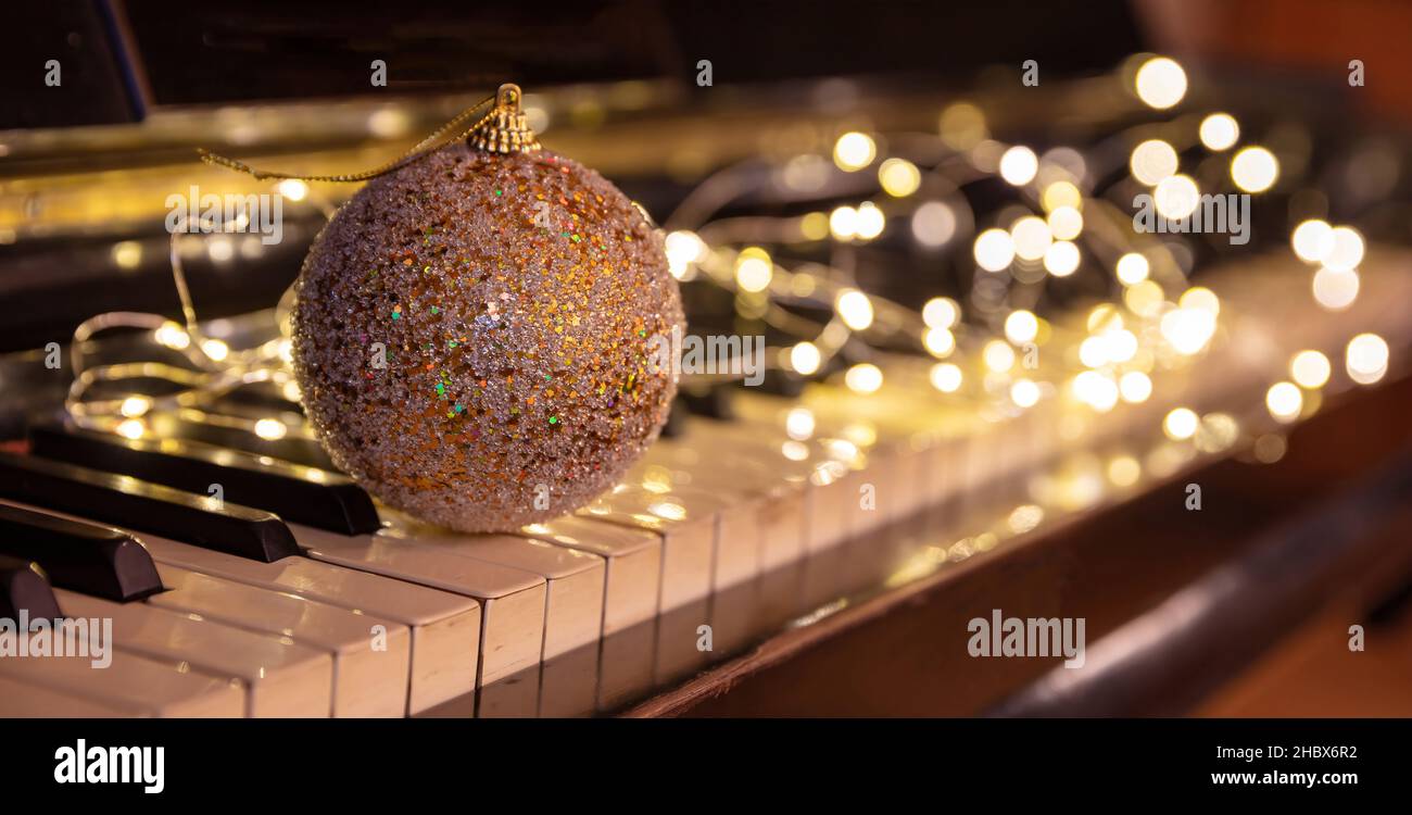 Christmas Piano music, Xmas decoration and lights bokeh background. Holiday celebration concert, party festive songs, Stock Photo