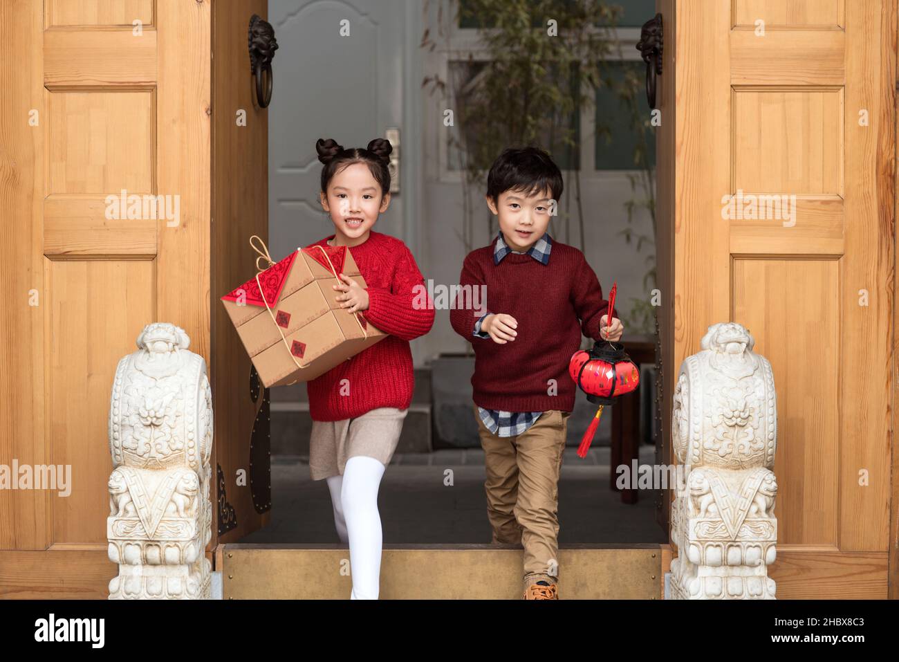 Brother and sister holding lanterns and gift boxes Stock Photo