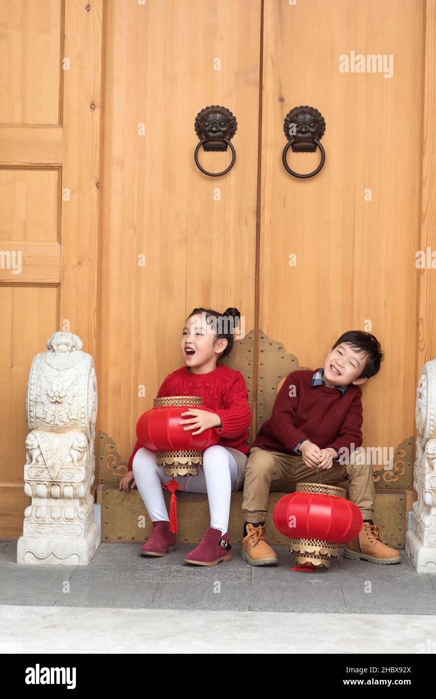 Brother and sister sitting at the door Stock Photo
