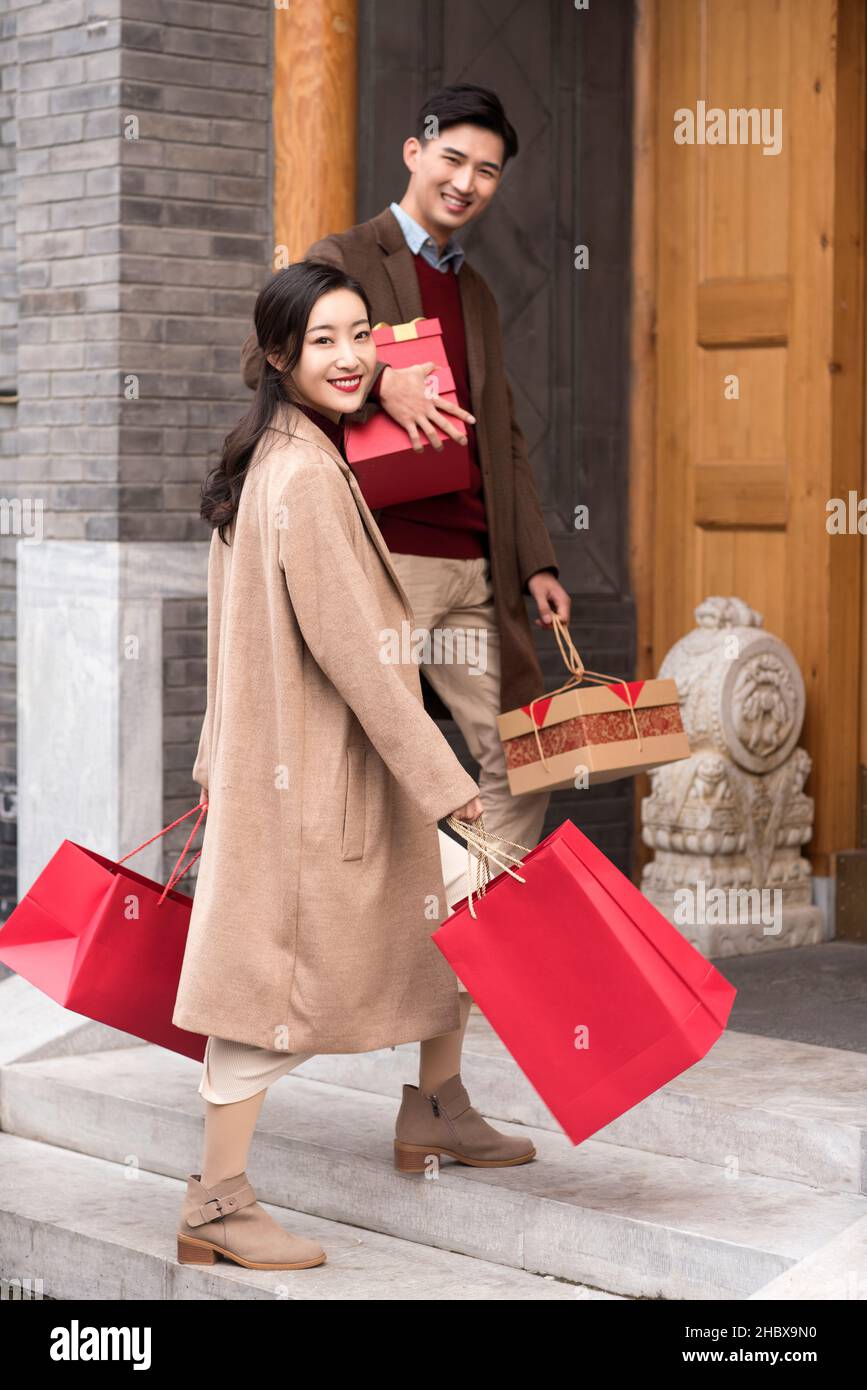 Happy young couple wishing the new year with gifts Stock Photo