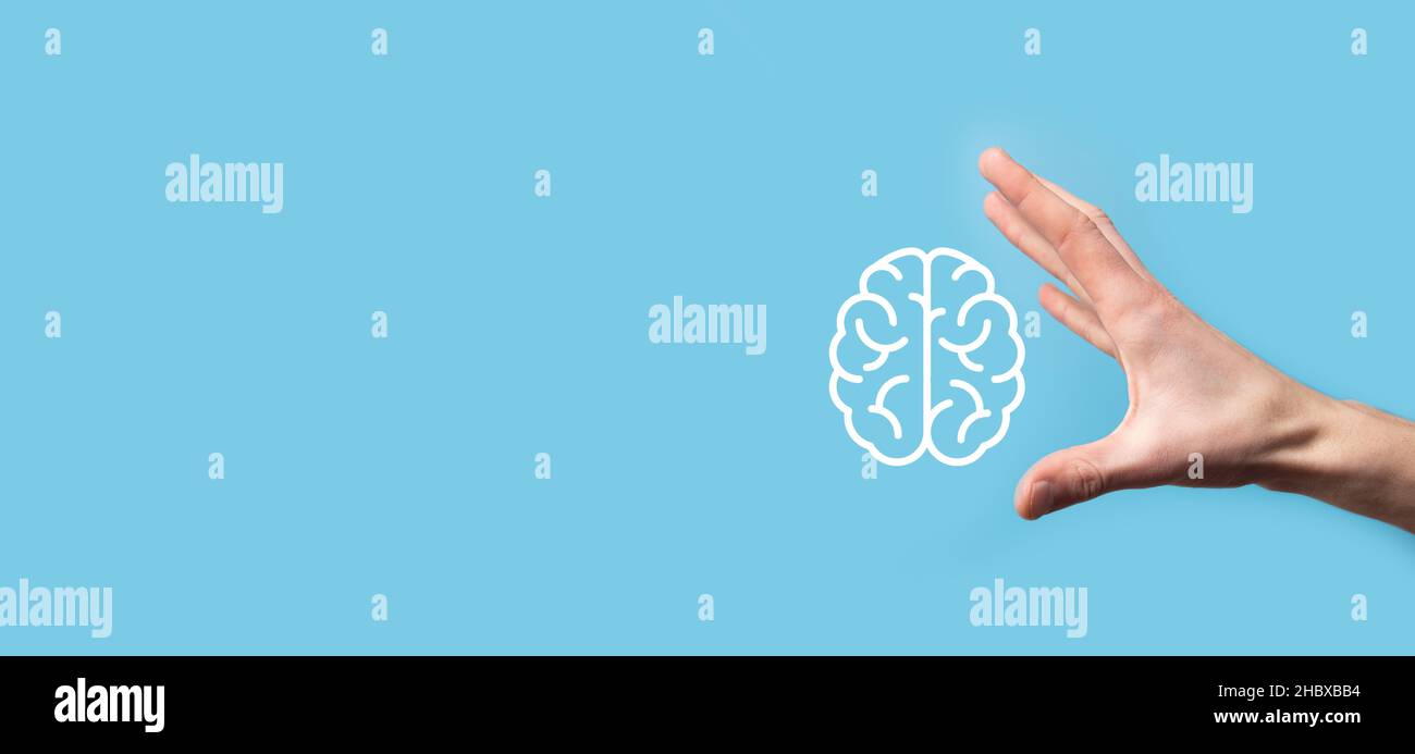 Male hand holding brain icon on blue background. Artificial ...