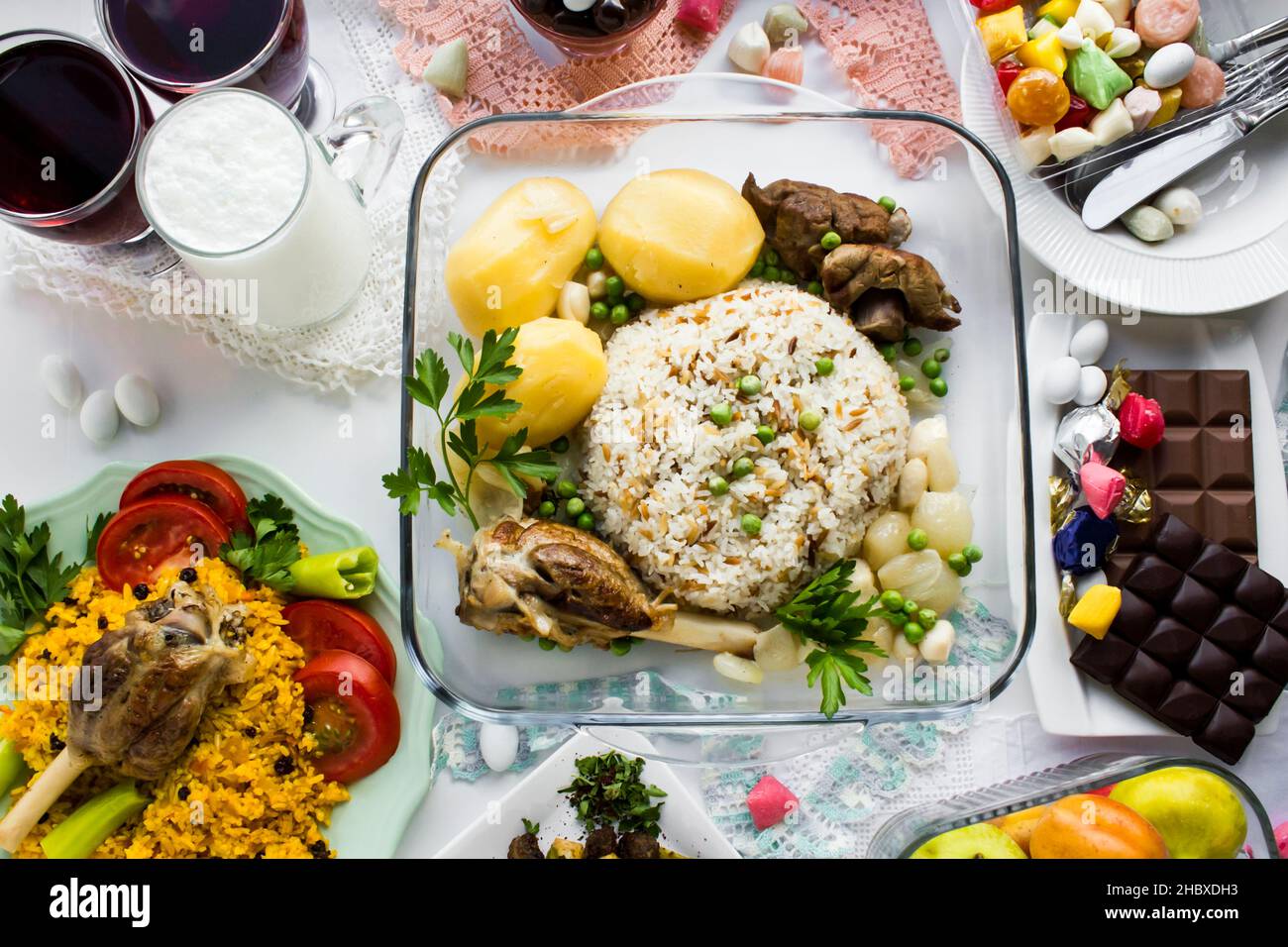 Traditional Turkish Islamic Feast,Sacrifice Dinner Table Kurban Bayrami in TR with rice,lamb shank,chocolate,fried liver,fruit and colorful candies. Stock Photo