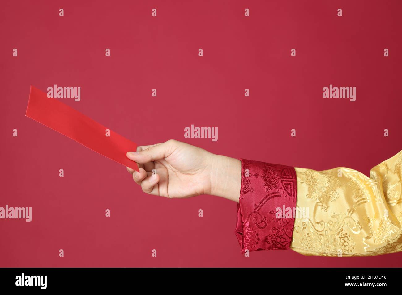 The Chinese man hand with tradion dressed on the red background. Stock Photo