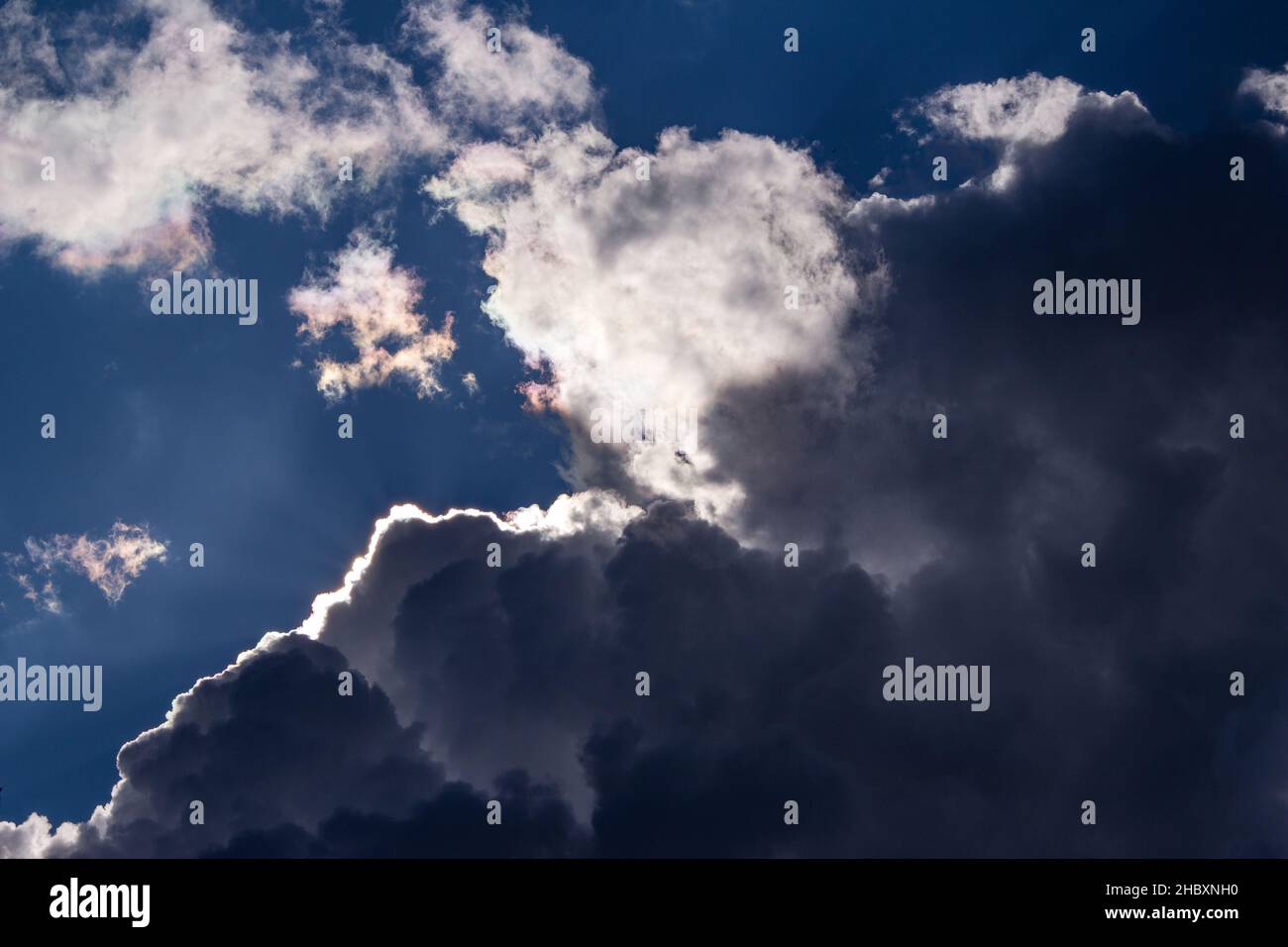 The sun disappeared behind powerful clouds in the blue sky Stock Photo